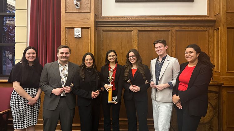 Seven young persons standing and holding awards