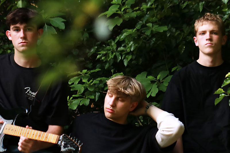 Three young male musicians outside