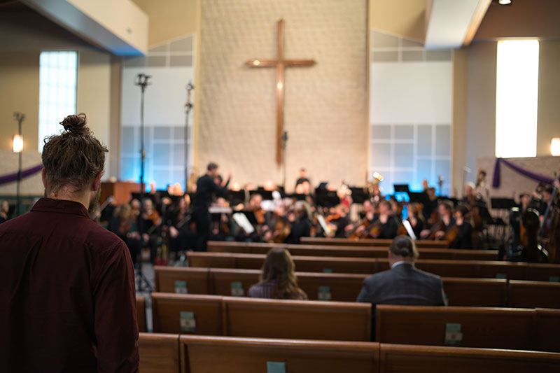 Audience watching an orchestra perform in a church