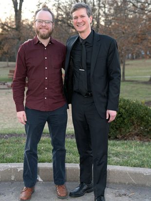 Two men standing outside smiling