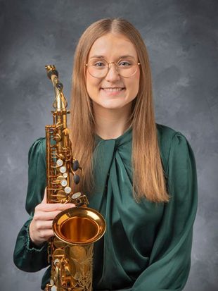 Formal head shot of young woman with saxophone