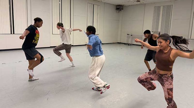 Five students rehearsing in a dance studio