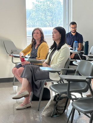 Two women listen to a presenter in a classroom