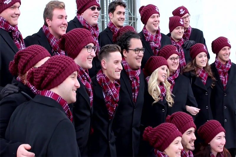 Group of young men and women in maroon winter hats and scarves
