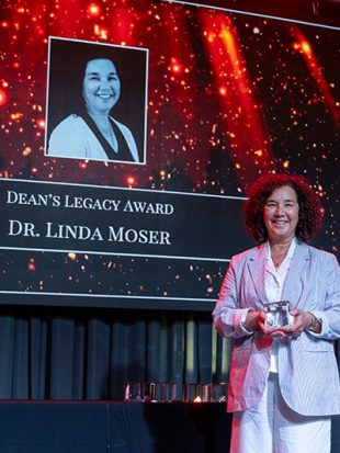 Linda Moser holds award on stage