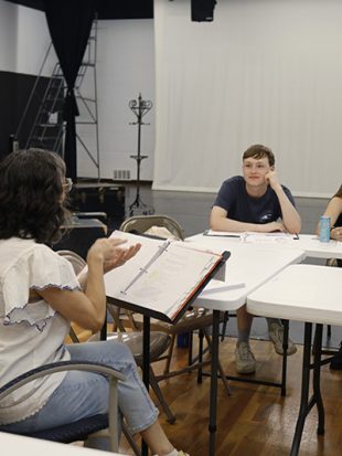 Woman giving actor direction at a script table reading