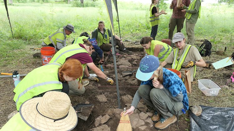 Several students working on an outdoor archaeological project