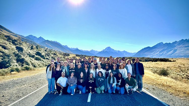 Group of people standing on highway in front of Mt. Cook in New Zealand