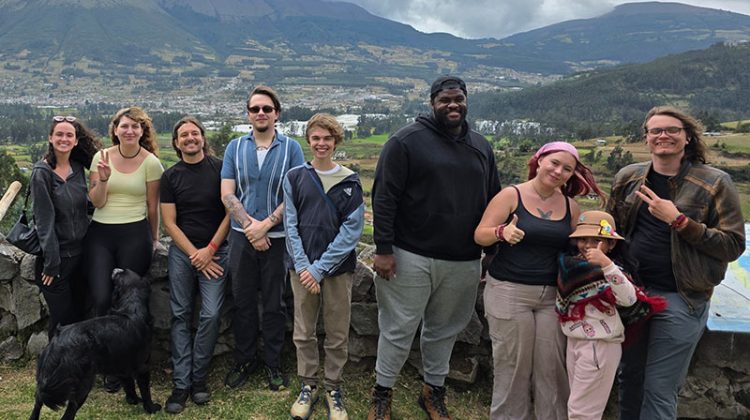 Nine people standing outside near Ecuador mountains