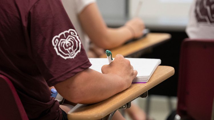 Student writing in class