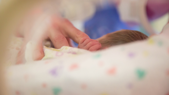 Infant grabbing the finger of an occupational therapist