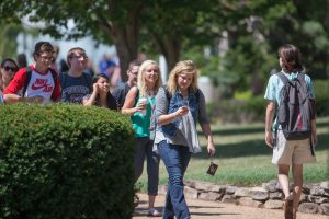 Students walking on campus while looking at smartphones