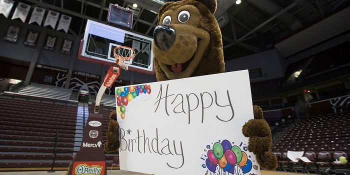 Boomer holds birthday sign on basketball court