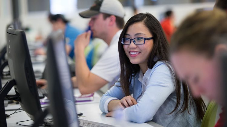 student smiling at a computer