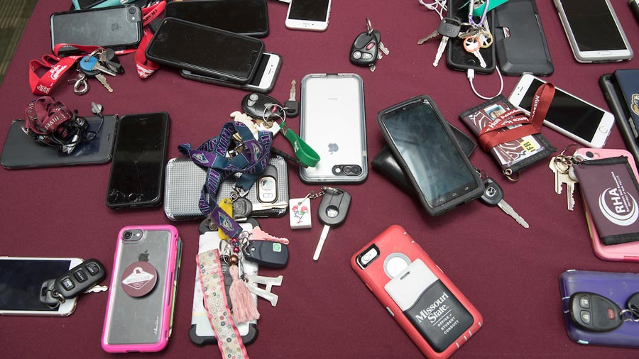 Smartphones and keys scattered on a maroon table
